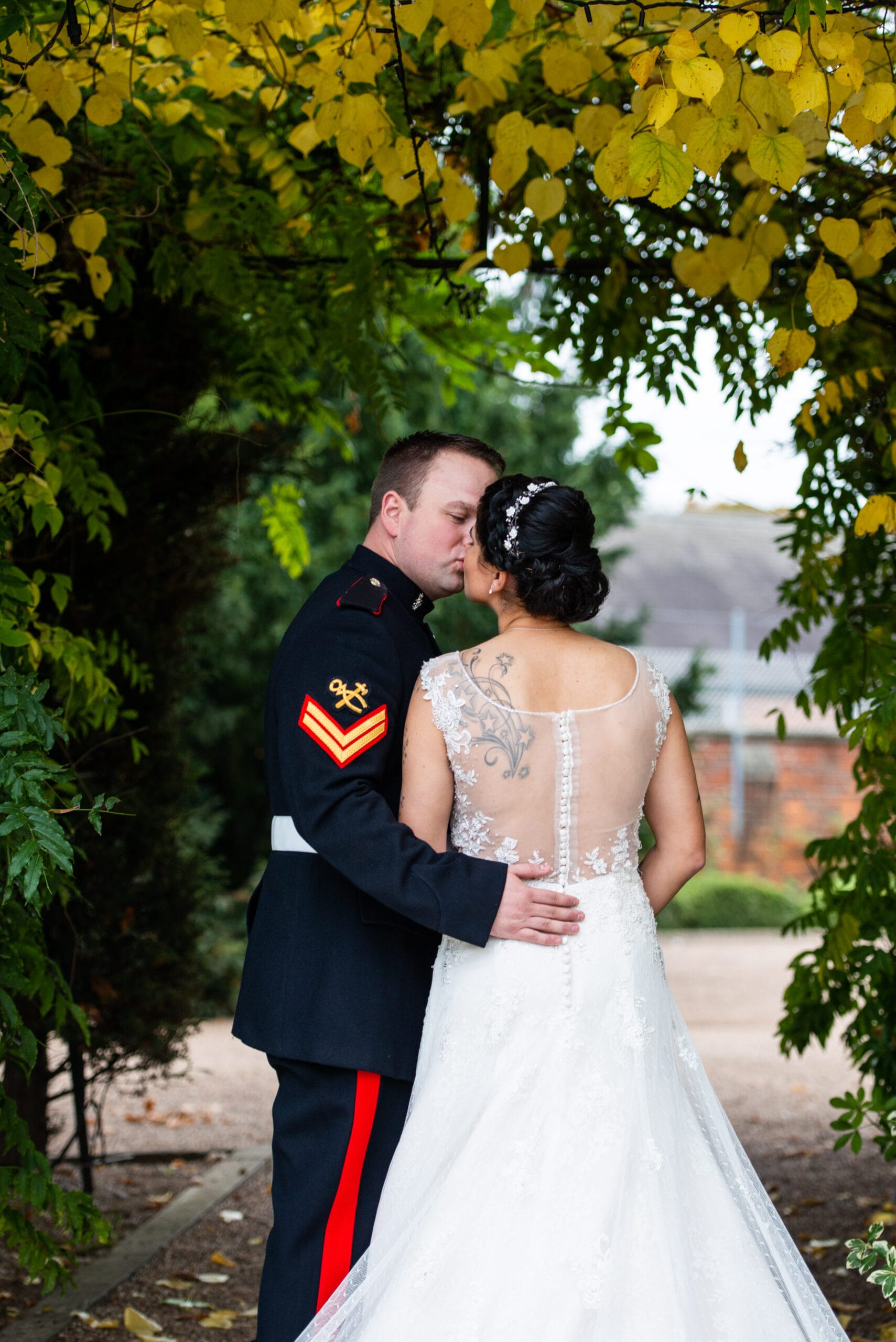 bride & groom kissing under automnal leaves during Nottingham wedding