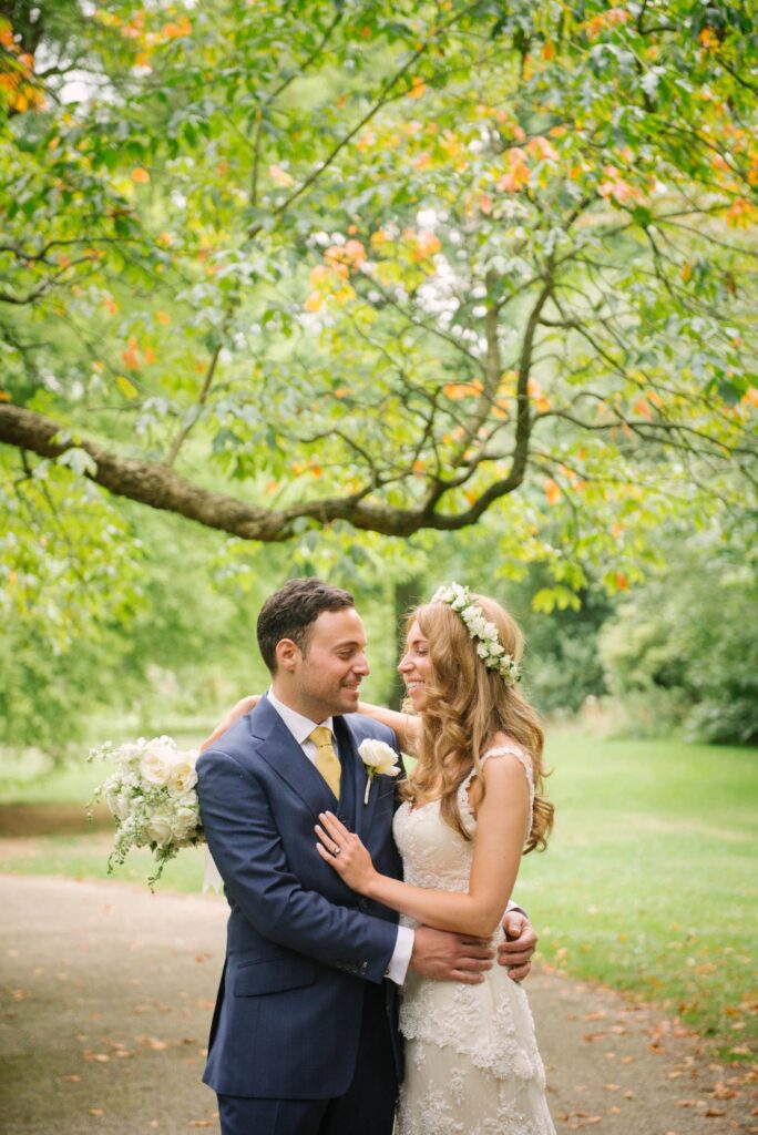 Bride and groom smiling in the grounds of Syon Park