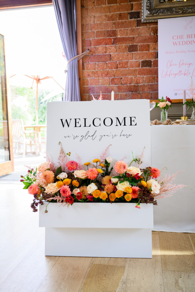 Welcome sign with rustic flowers at Carriage Hall wedding venue