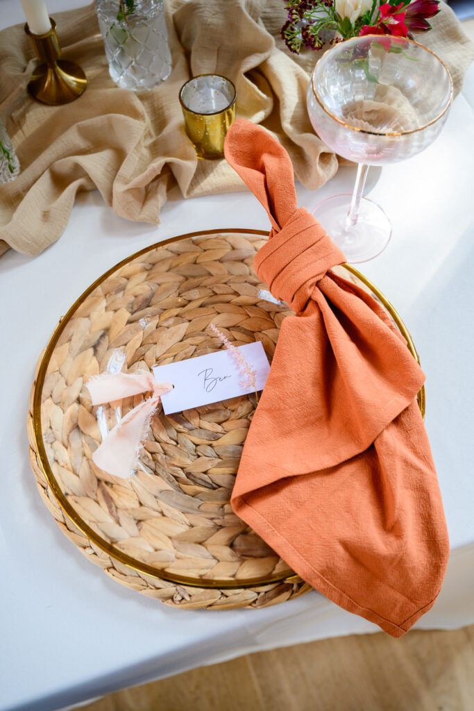 burnt orange napkin on rustic glass plate at Carriage Hall wedding