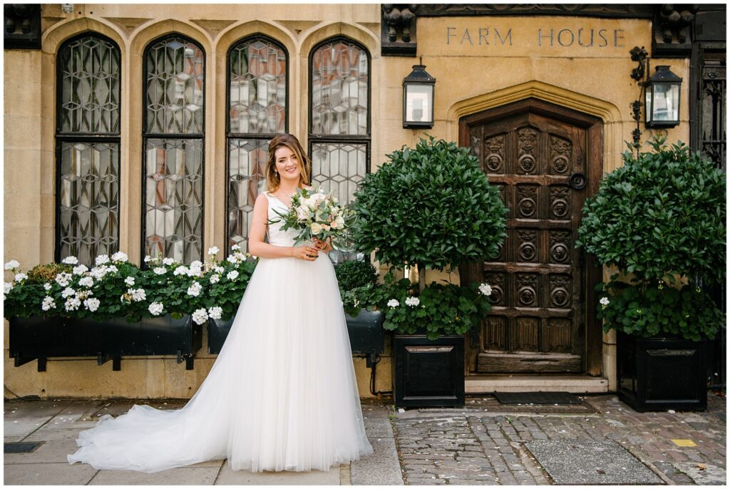 Bride stood smiling outside of Farm Street Church on Summer Wedding Day