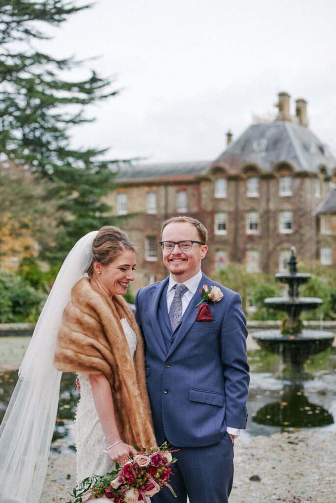 Bride and groom laughing during winter wedding at De Vere Beaumont Estate