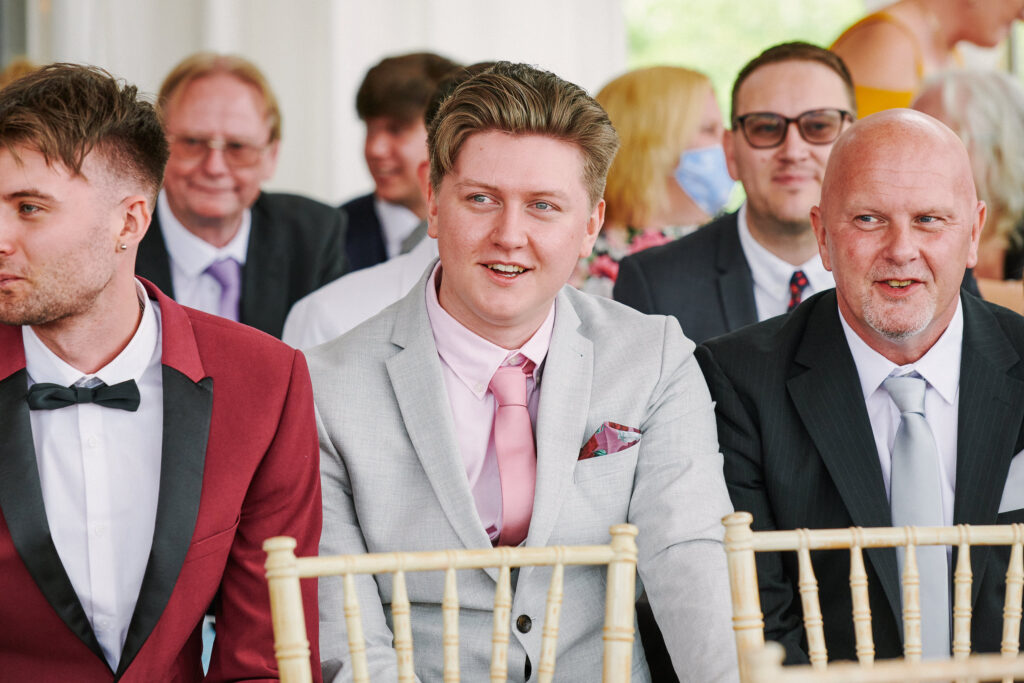 wedding guest smiling during ceremony inside The River Rooms