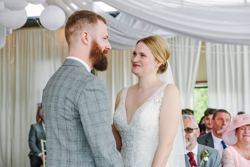 Bride and groom stood smiling during wedding ceremony in the river rooms