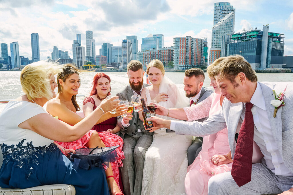 wedding guests toasting on a boat on the river thames