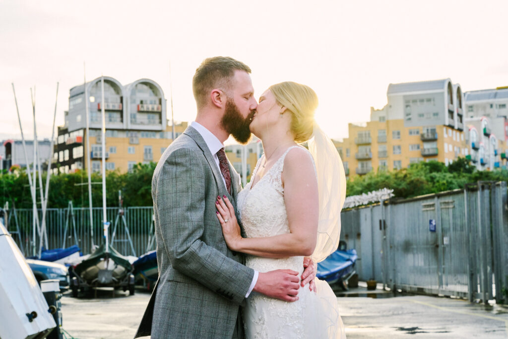Wedding couple kissing in the boat yard at Greenwich Yacht Club