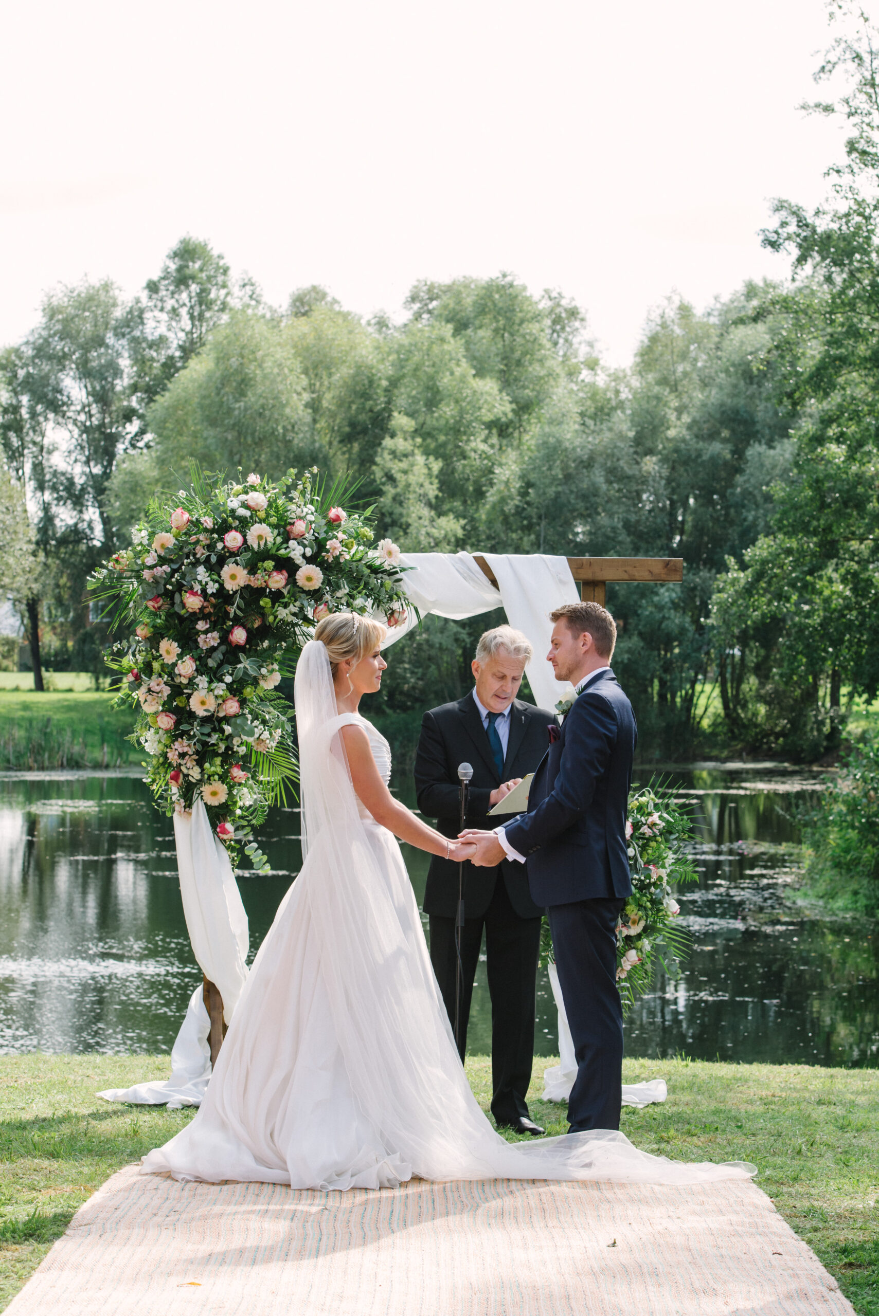 bride & groom during their outdoor wedding ceremony at Halliford Mere Lakes