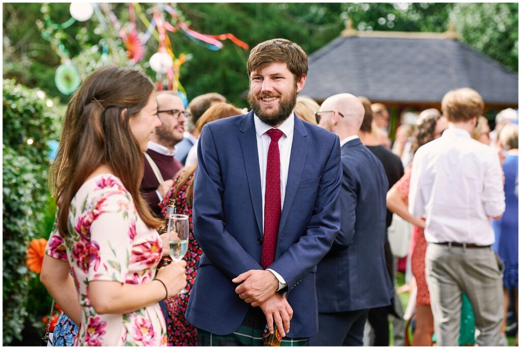 Guest laughing during summer garden party wedding reception in Brighton