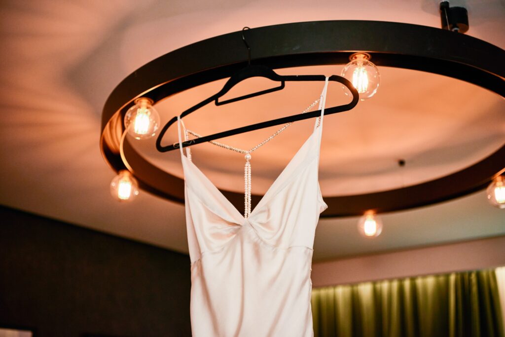 wedding dress hung on chandelier in London hotel room