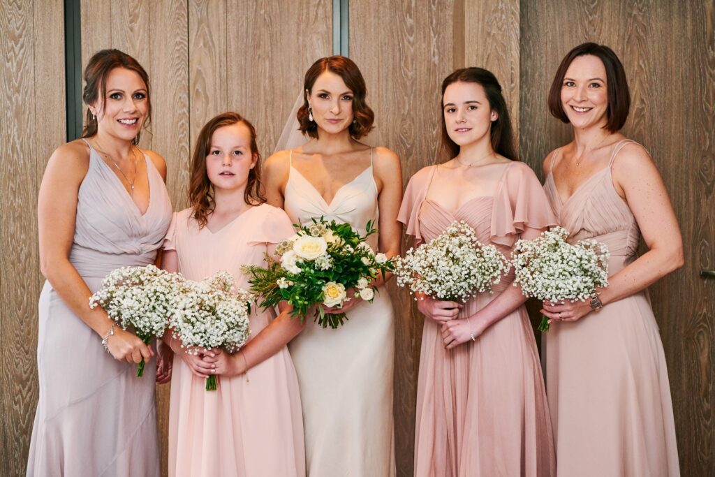 Bride stood with her bridesmaids in a London hotel room on her wedding day