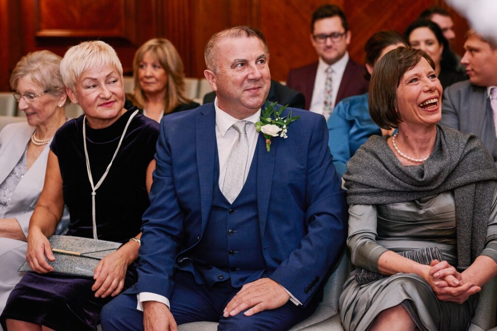 wedding guests smiling in the Westminster ceremony room at Old Marylebone Town Hall