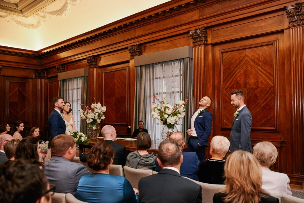Bride and groom watching two singers during their ceremony at Old Marylebone Town Hall