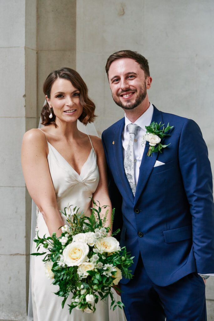 Bride & groom smiling in front of The Old Marylebone Town Hall building