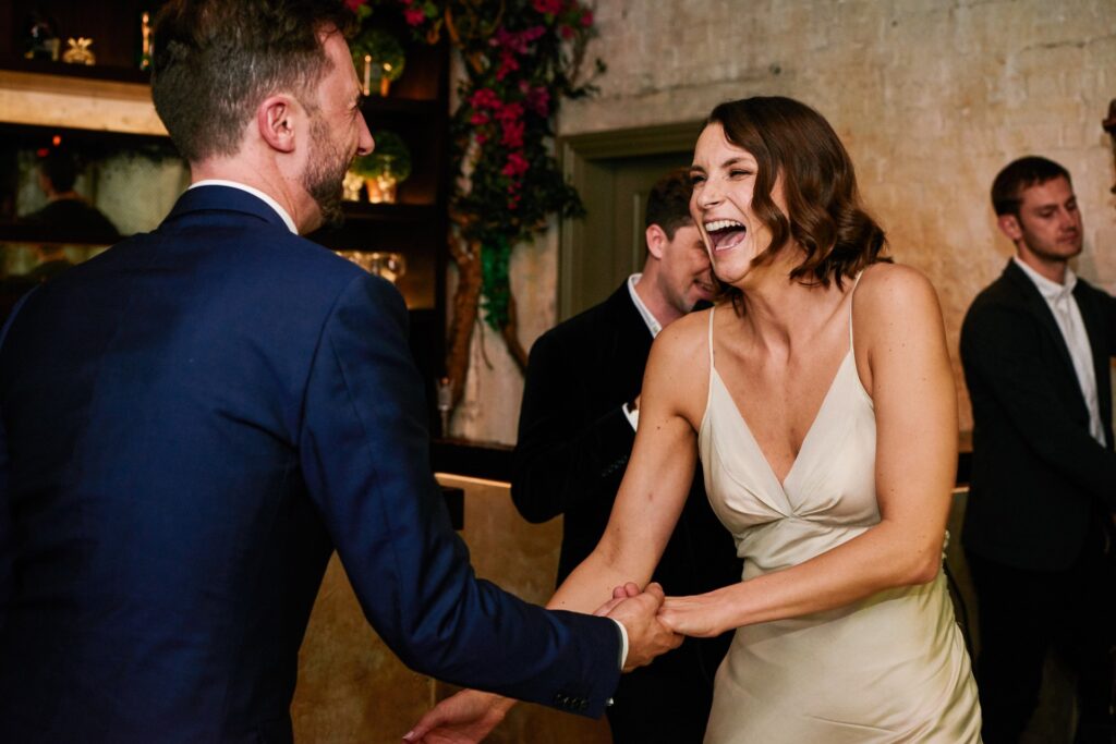 Bride & groom laughing during their first dance in the Olive Grove room at Union Street Café 