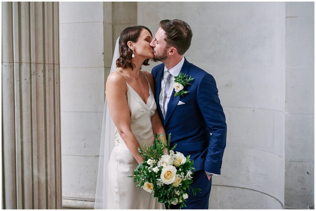 Bride & groom kissing in front of The Old Marylebone Town Hall building