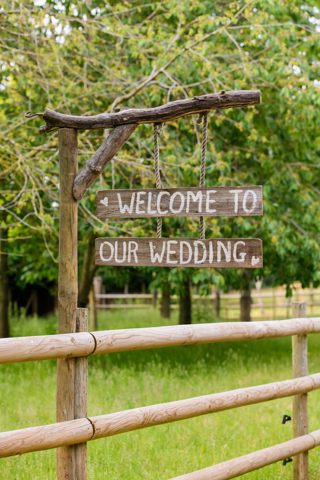 rustic wooden welcome sign in front of a woodland
