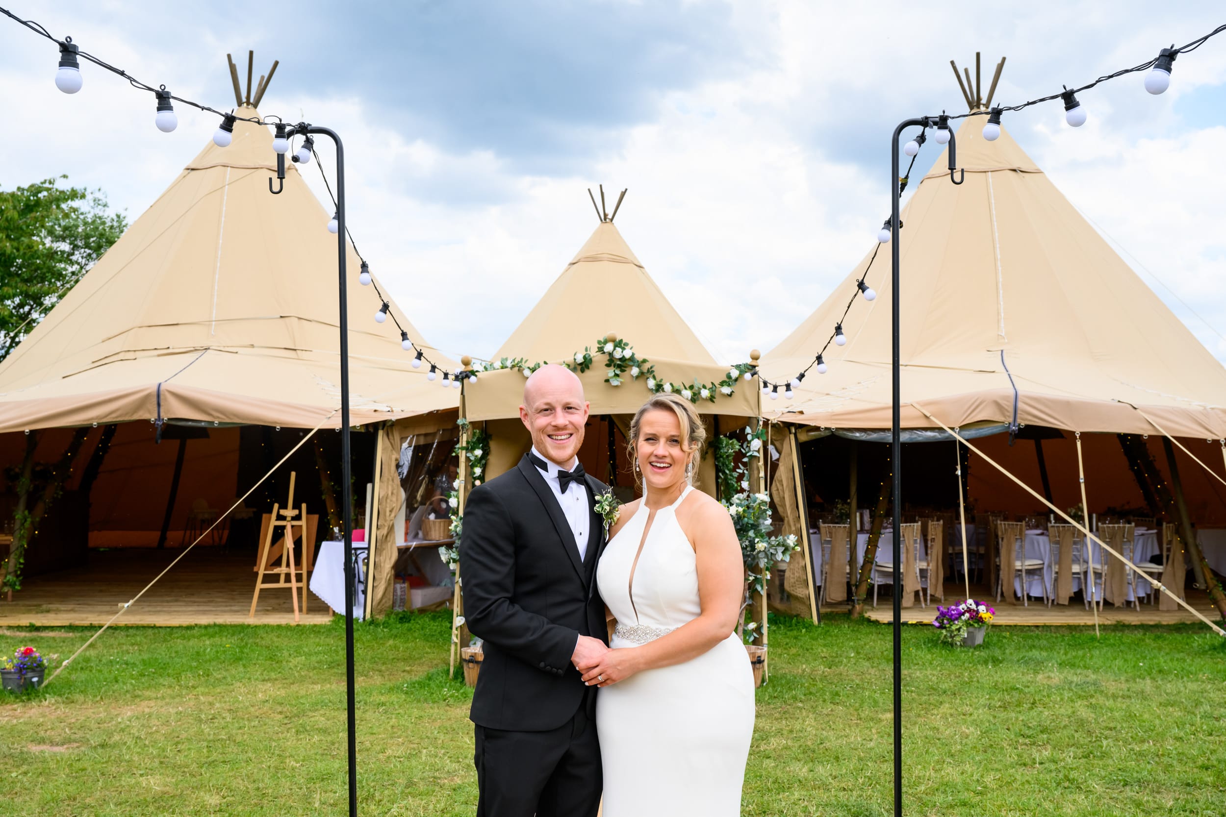 Bride and groom in front of a tipi during their festival wedding in Nottingham