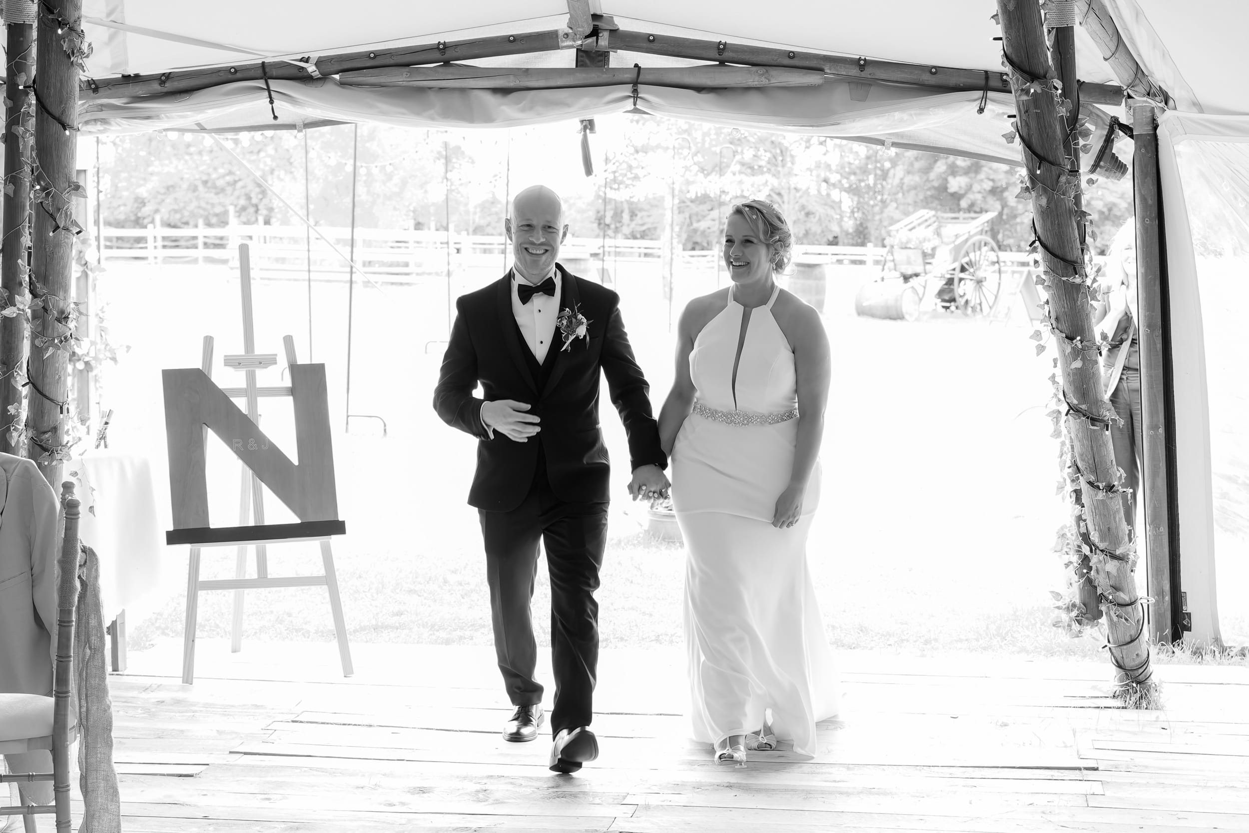 Bride and groom walking into their tipi wedding reception at Overgrown Acres