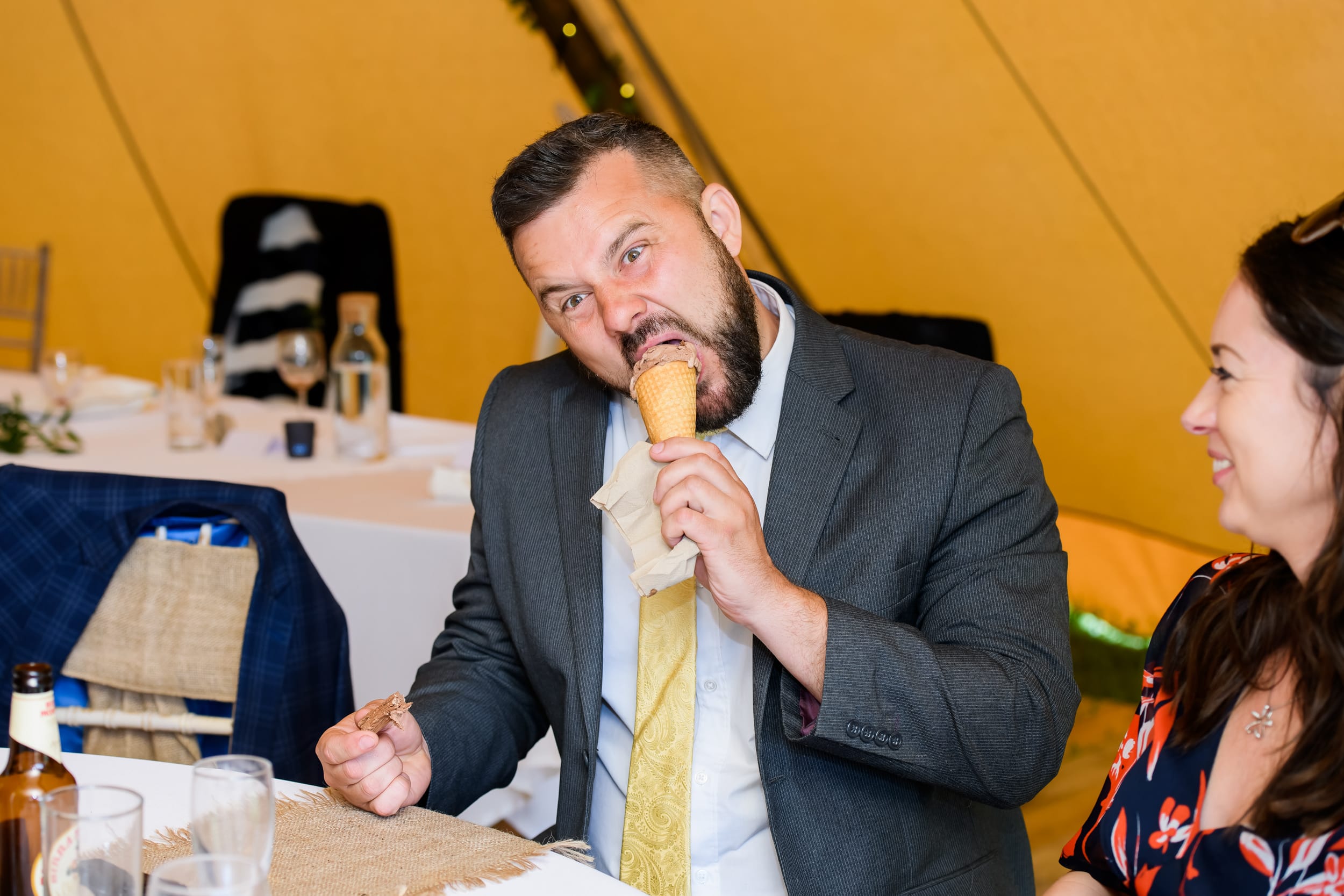 Wedding guest having fun and stuffing an ice cream in his face