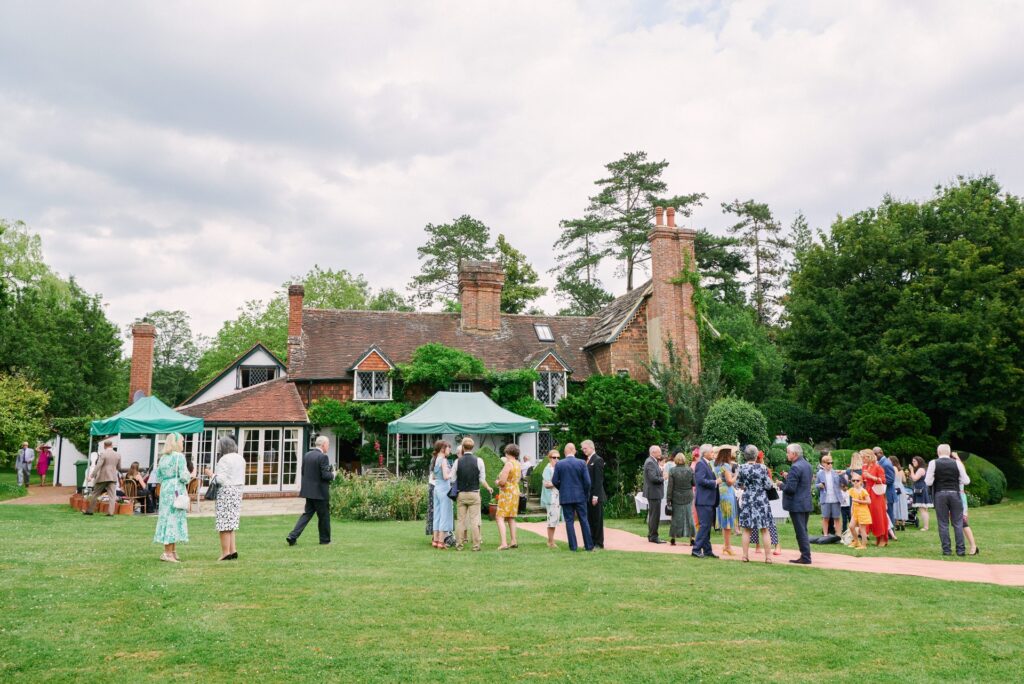 Wedding guests enjoying canapes behind the farmhouse at Ridge Farm