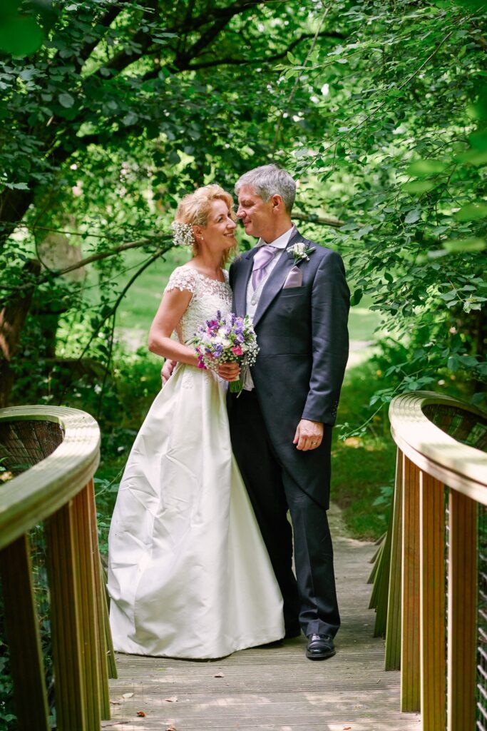 bride and groom kissing on the bridge at Ridge Farm wedding venue