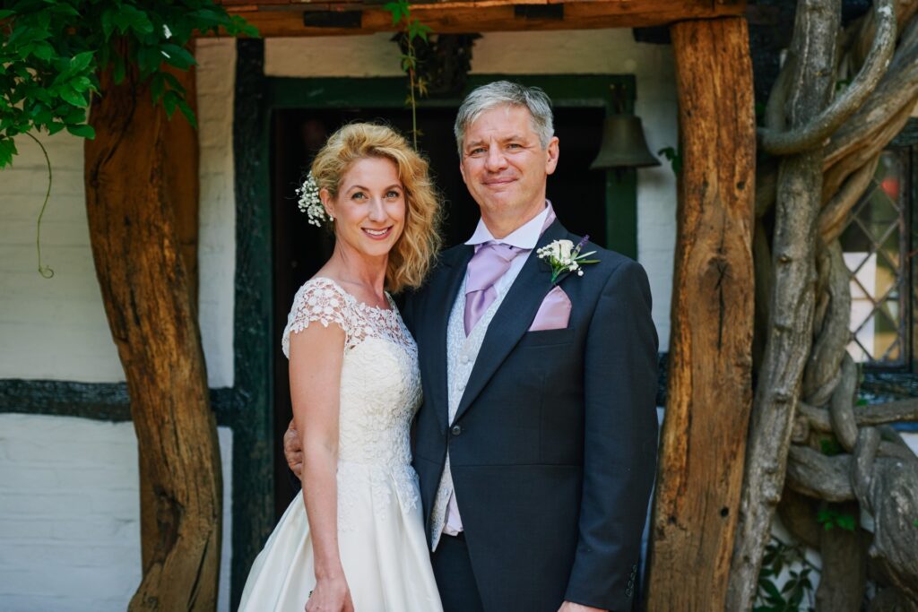 Bride and groom in front of the farmhouse at Ridge Farm wedding venue