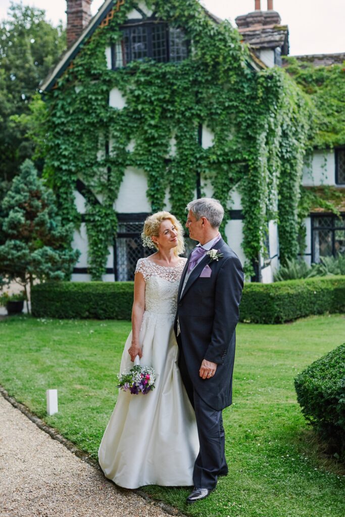 bride and groom smiling in front of the farmhouse at Ridge Farm