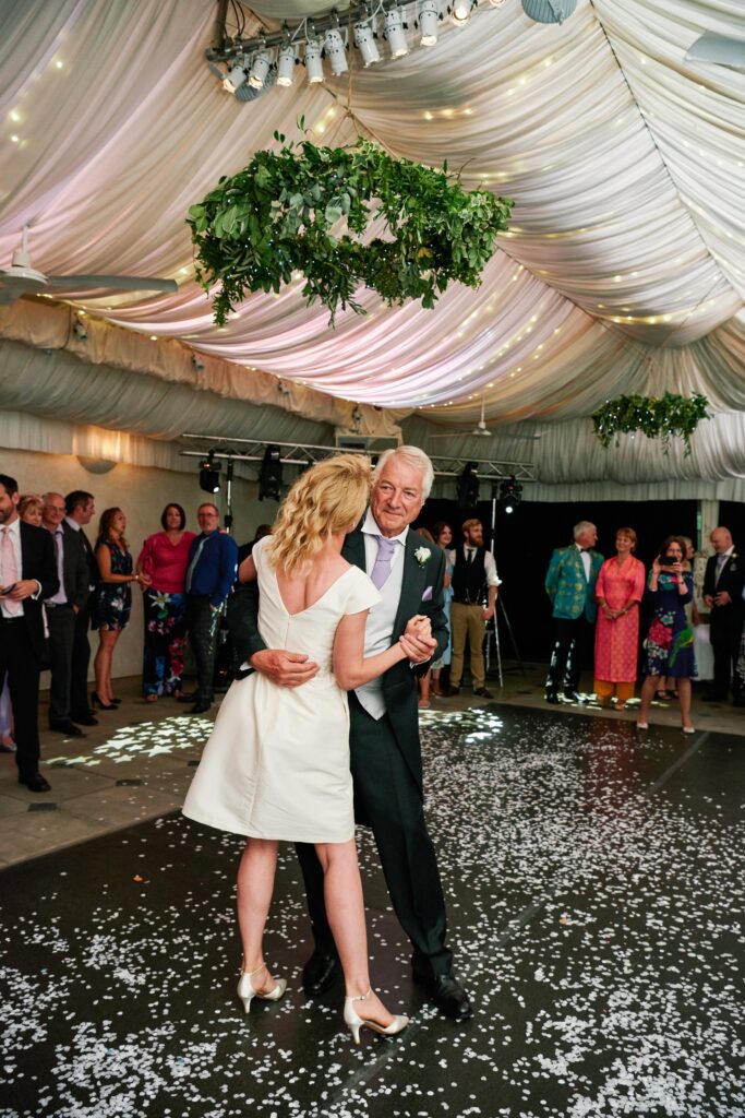 bride and her dad dancing in the pool house reception room