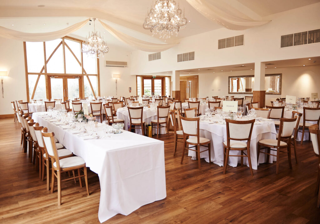 Wedding breakfast tables set up in the grain store room at Mythe Barn