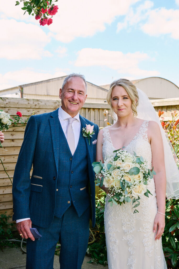 Bride with her dad stood outside on a sunny day