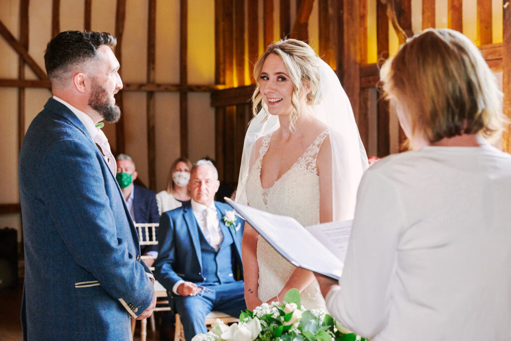Bride & groom smiling during rustic wedding ceremony at Stokes Farm Barn