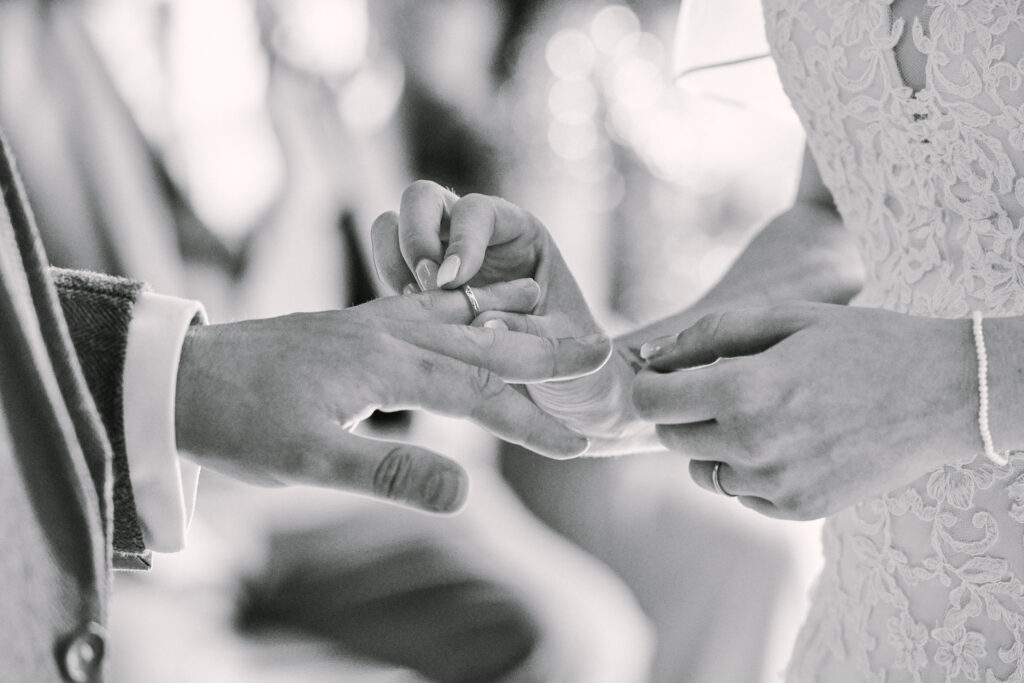 Close up photography of bride & grooms hands exchanging wedding rings