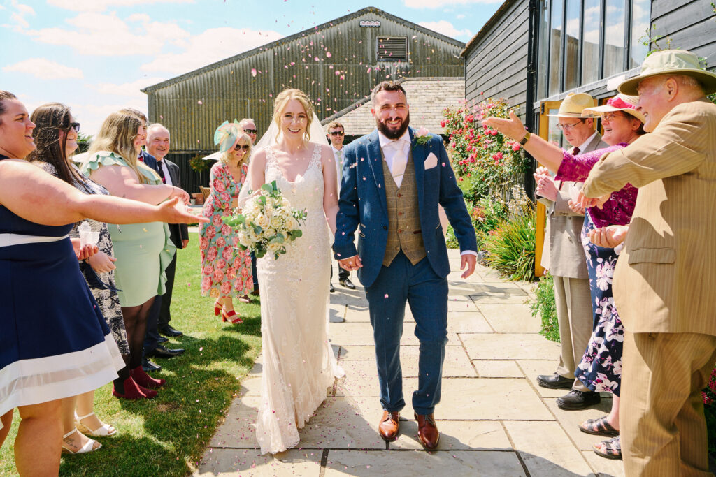 wedding couple walking through confetti outside stokes farm barn