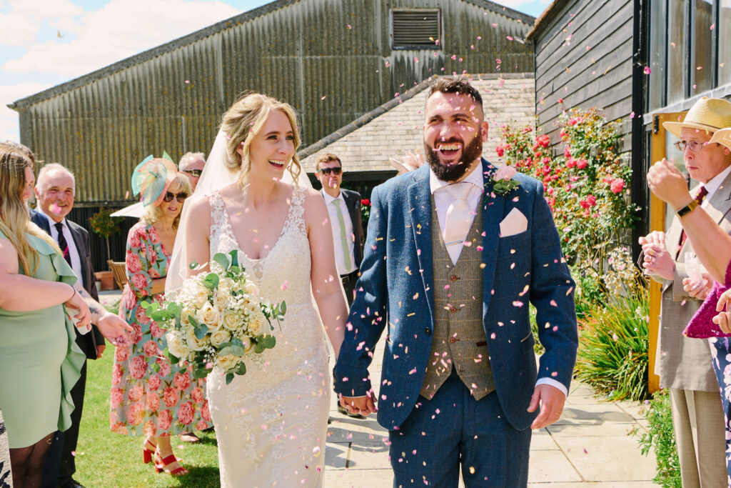 wedding couple walking through confetti outside at stokes farm barn