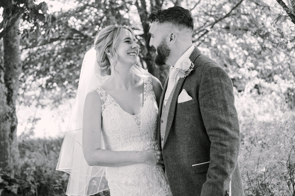 Bride and groom smiling together during their wedding photography session 