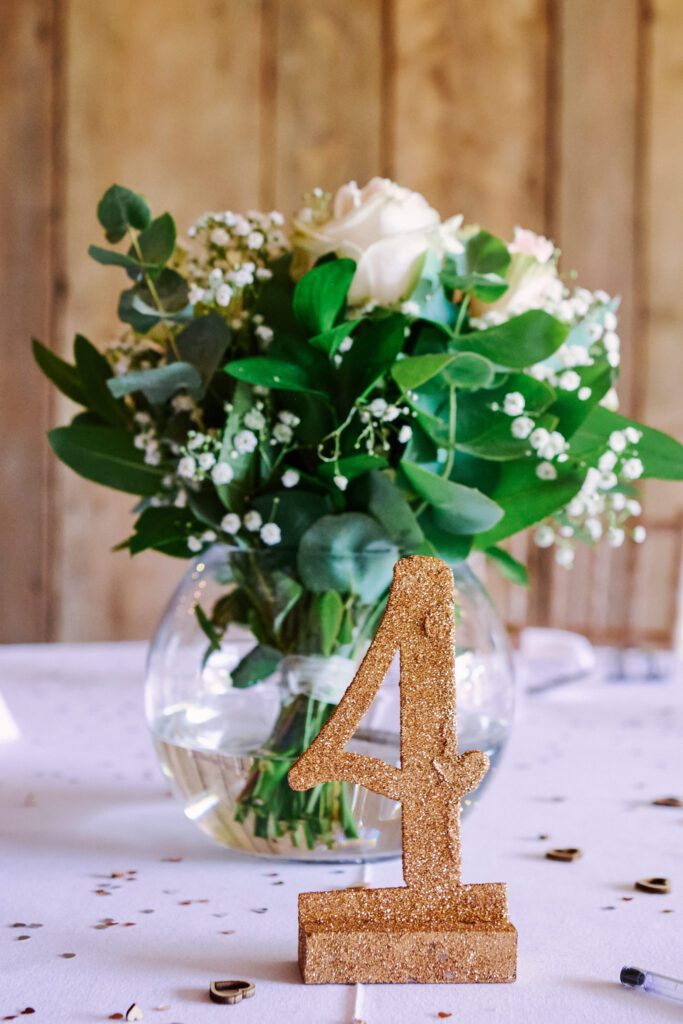 wedding table details showing a number 4 and flowers