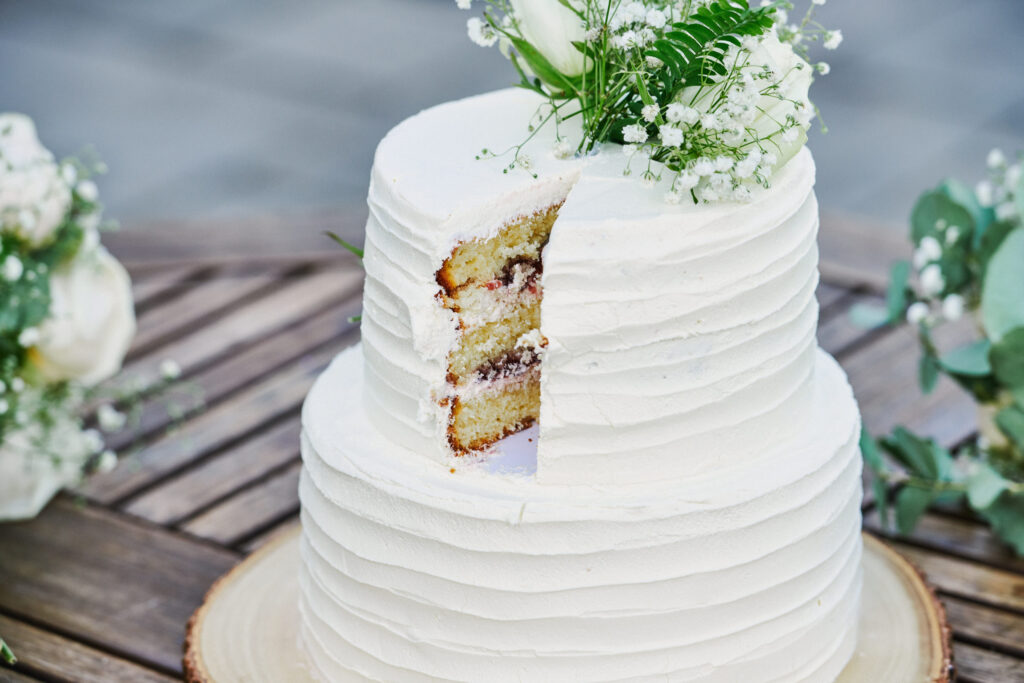 white wedding cake with a slice cut out of it