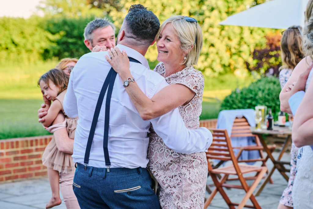 wedding guests dancing together outside on sunny wedding day