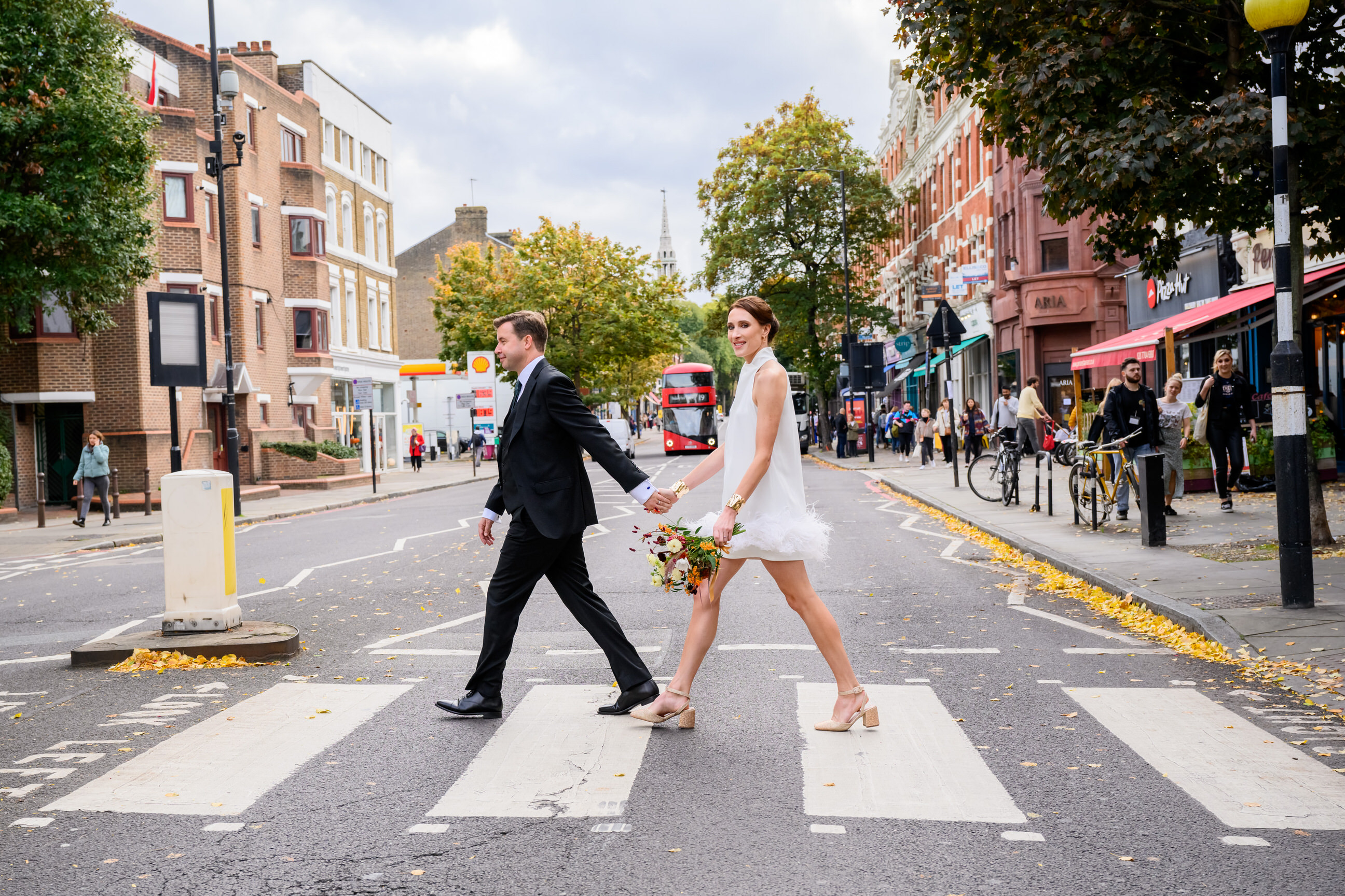 bride and groom walking across zebra crossing on their to Islington Town Hall Wedding