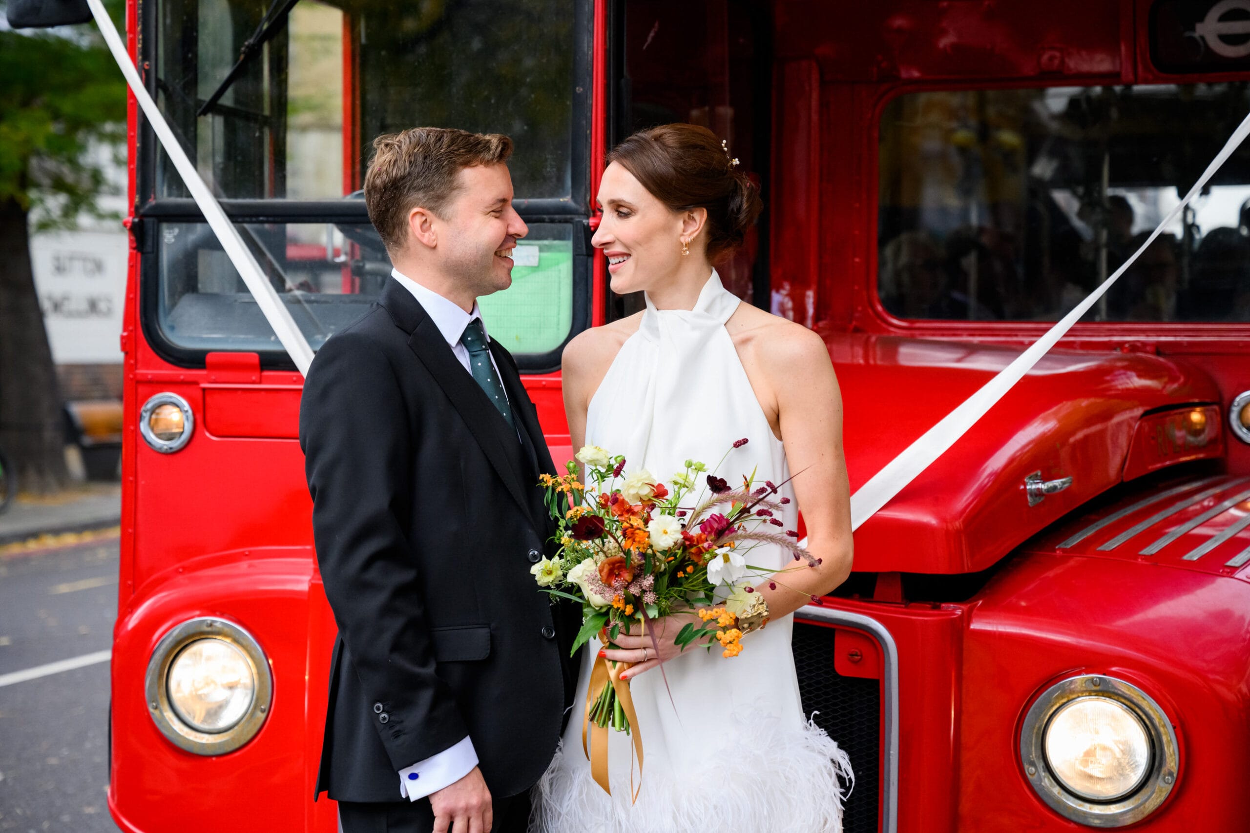 natural photography portrait of bride and groom in front of red london route master bus