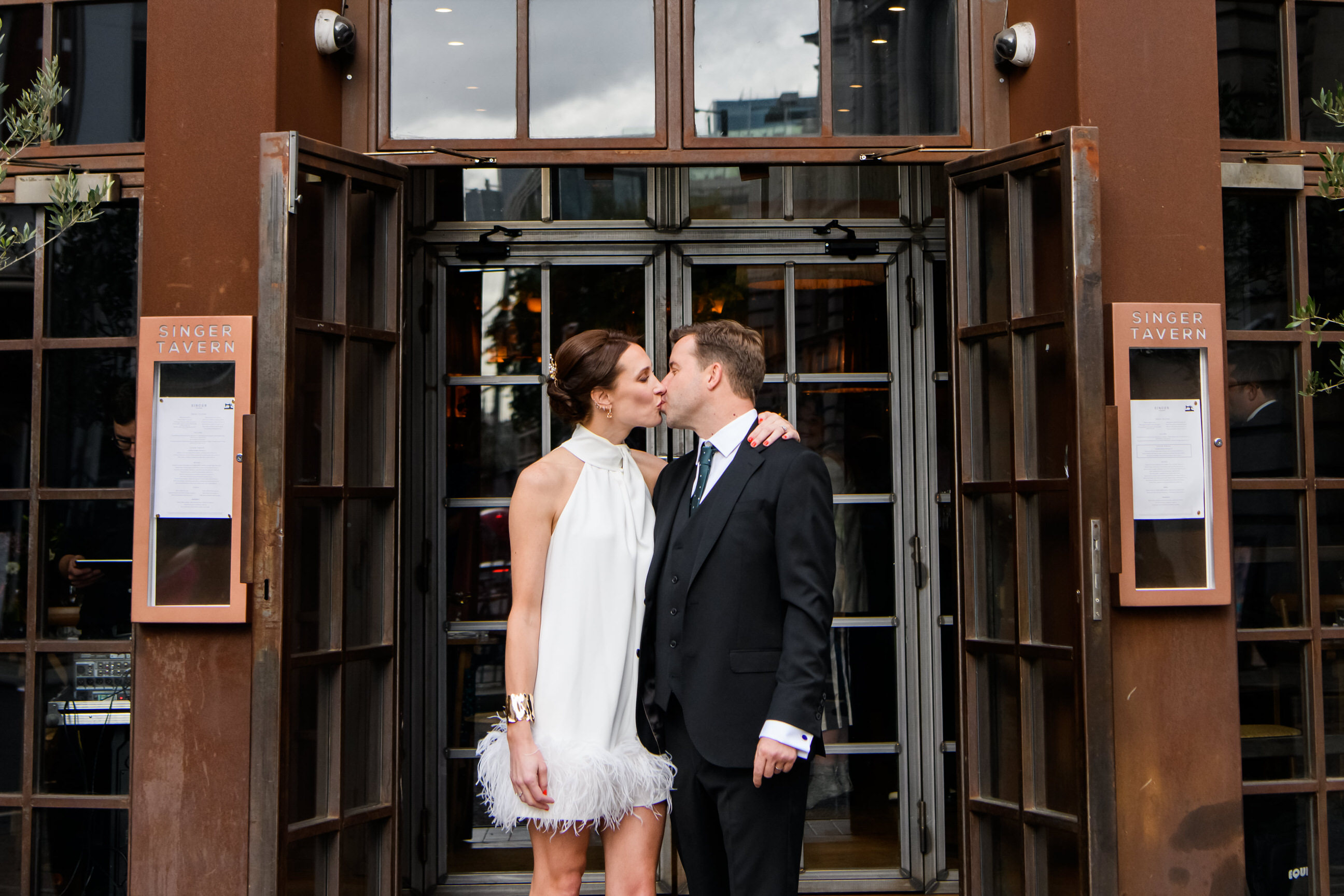 Bride and groom kissing in front of The Singer Tavern wedding reception venue