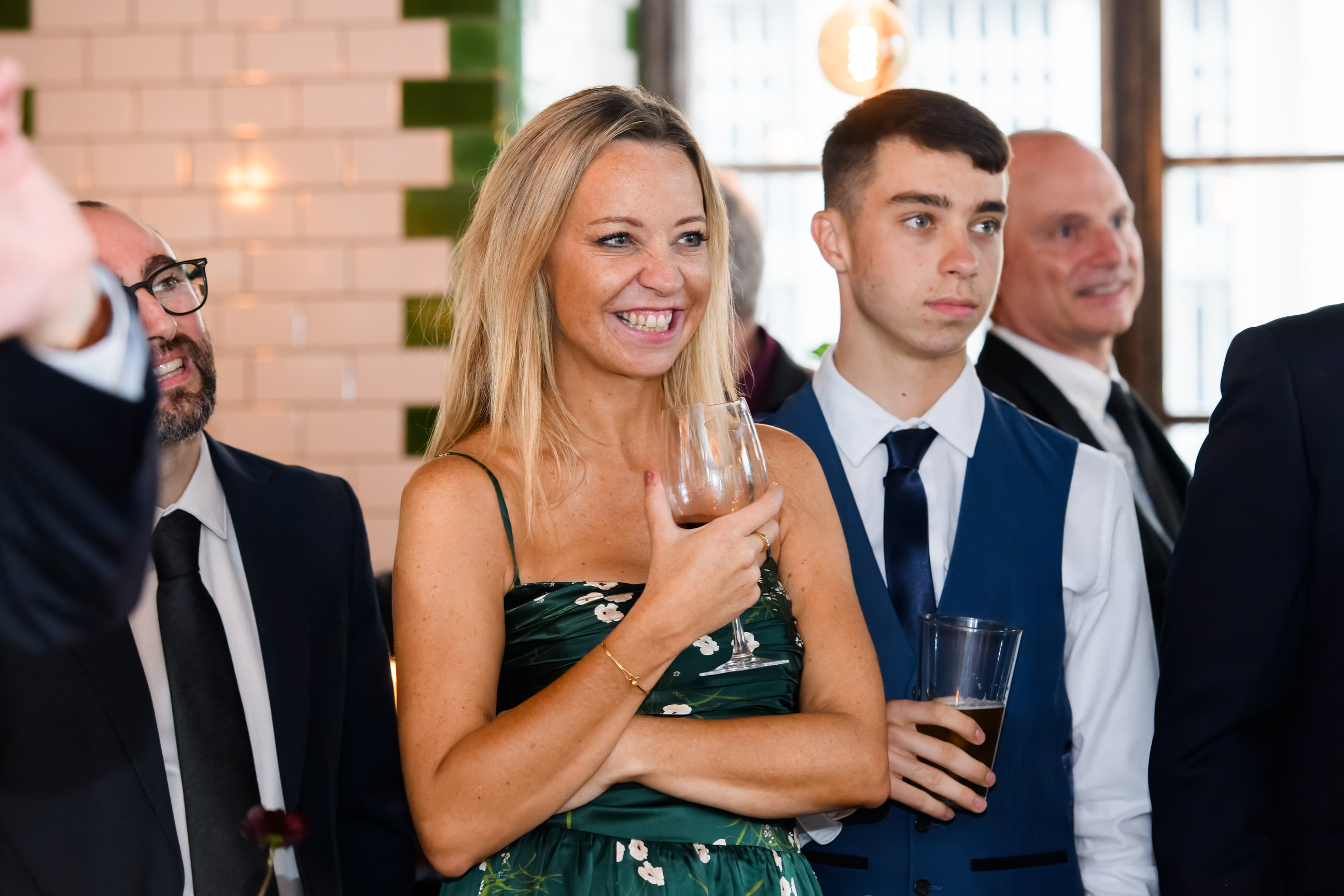 Wedding guests smiling whilst holding wine at The Singer Tavern Wedding Venue