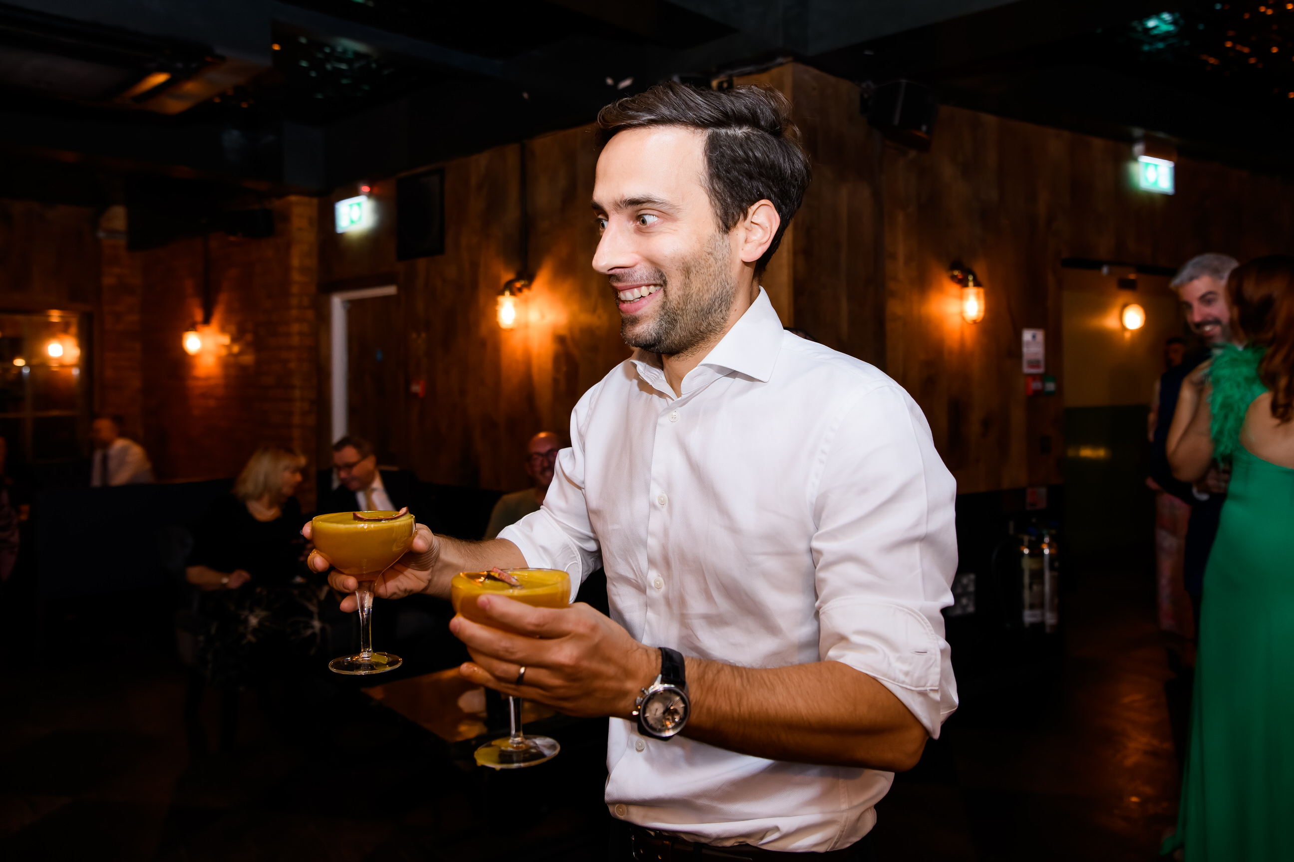 Wedding guest carrying cocktails during London pub wedding