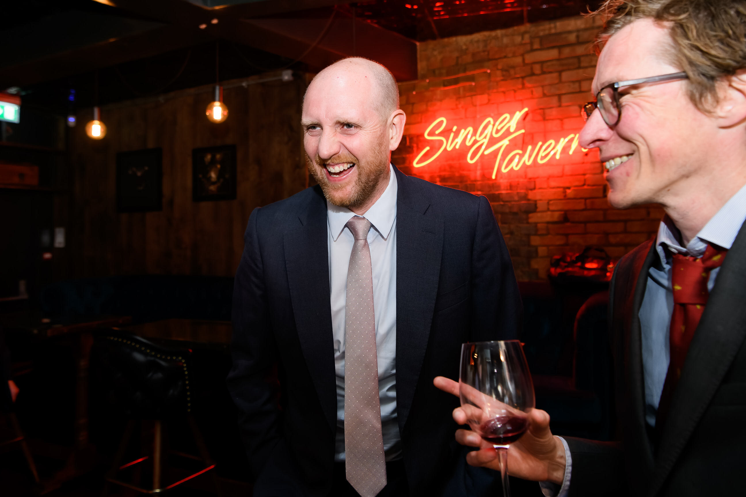 Candid photography of guest laughing during alternative London pub wedding
