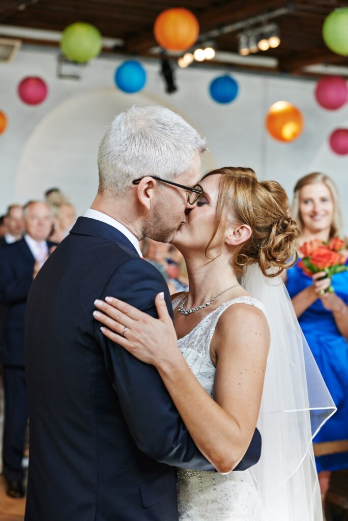 Wedding couple kissing during ceremony at Trinty Bouy Wharf Warehouse Wedding Venue