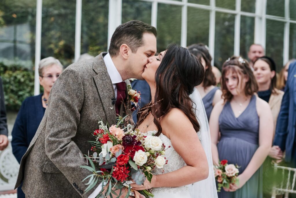bride and groom kissing during their wedding at The Horniman Museum conservatory