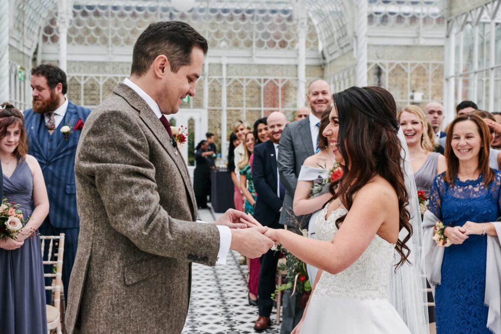 Wedding couple exchanging rings in the conservatory at The Horniman Museum