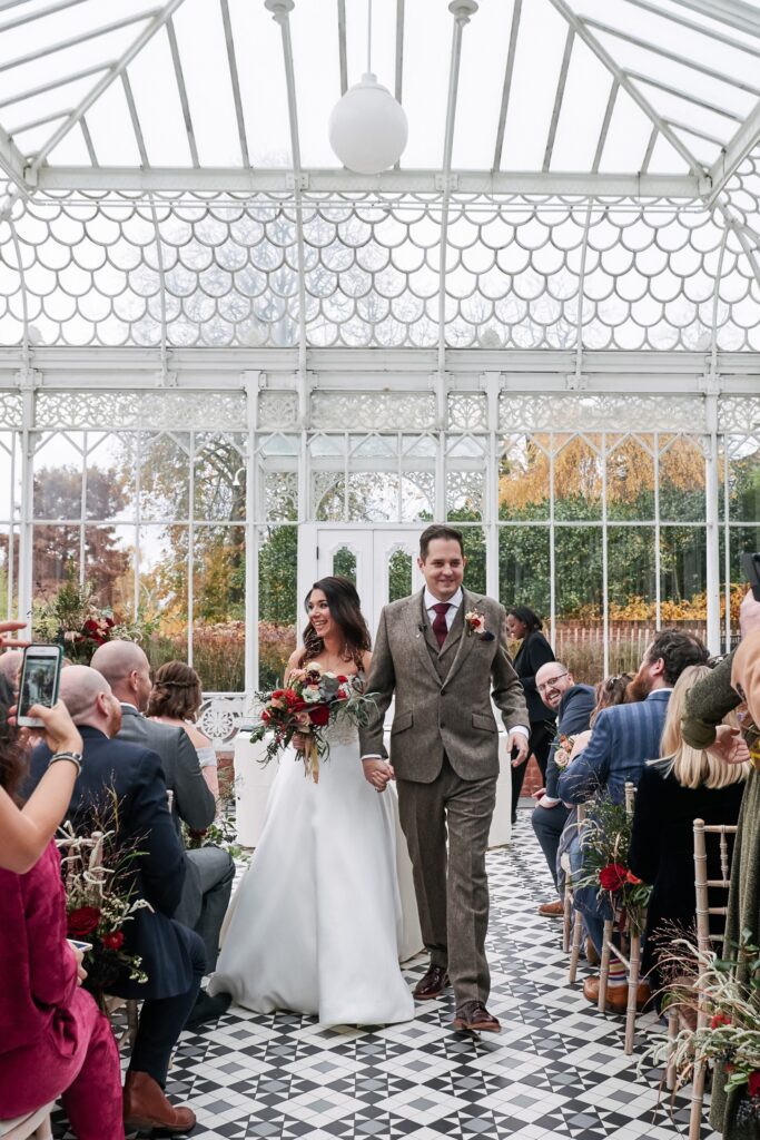 bride and groom walking down the aisle at The Horniman Museum conservatory