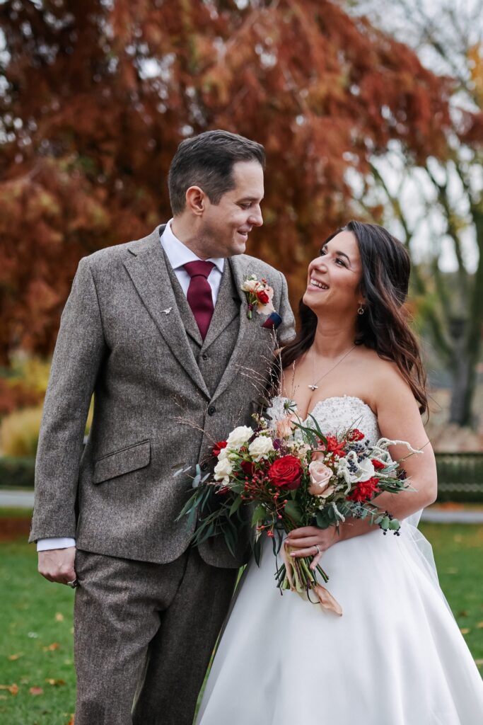 bride and groom laughing in the autumnal gardens at The Horniman museum. 