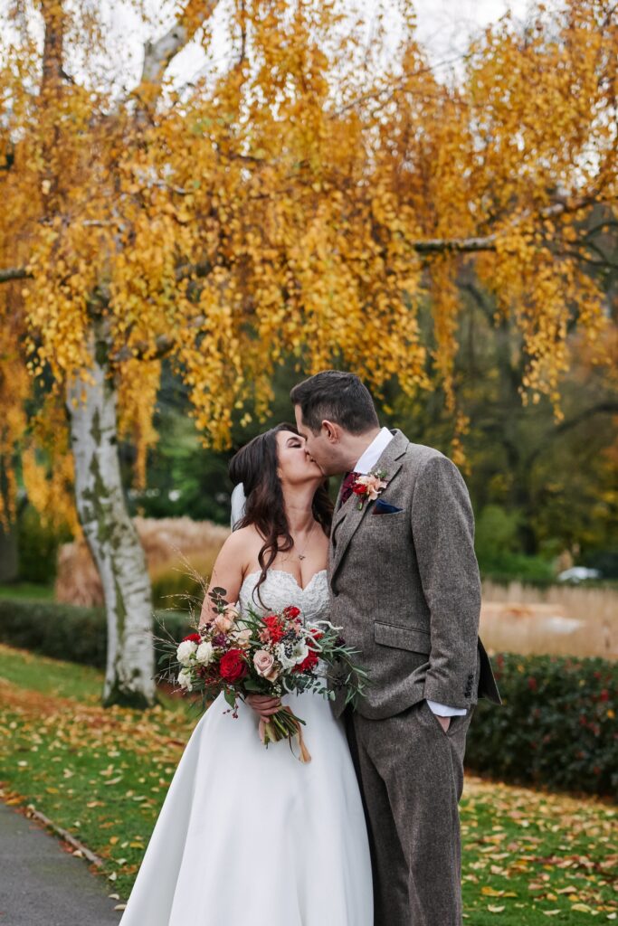 bride and groom kissing in the autumnal gardens at The Horniman museum